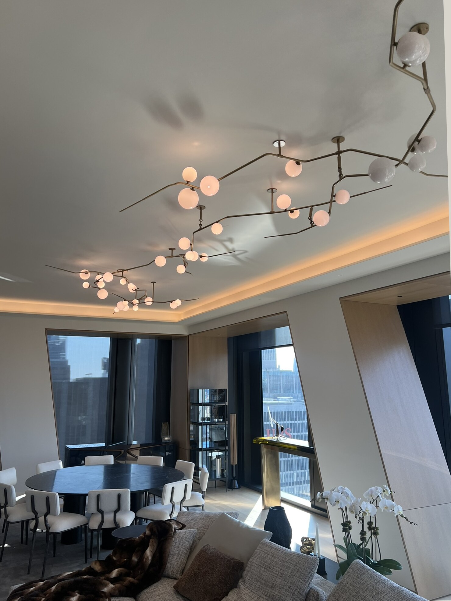 Level view of a high-rise residence with sculptural ceiling lighting and integrated shades